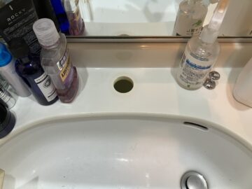 旧水栓を取り外した状態。洗面台カウンターに取り付け穴が露出している。