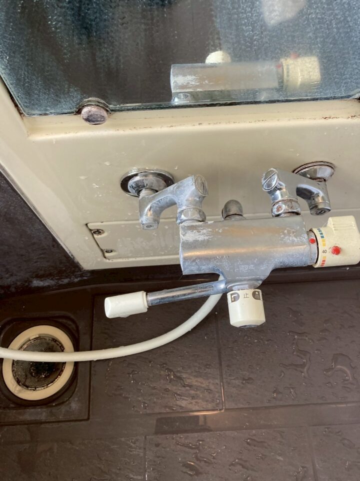 撤去前の既存サーモスタット水栓。温度目盛り付きで経年劣化・水垢固着が見られる