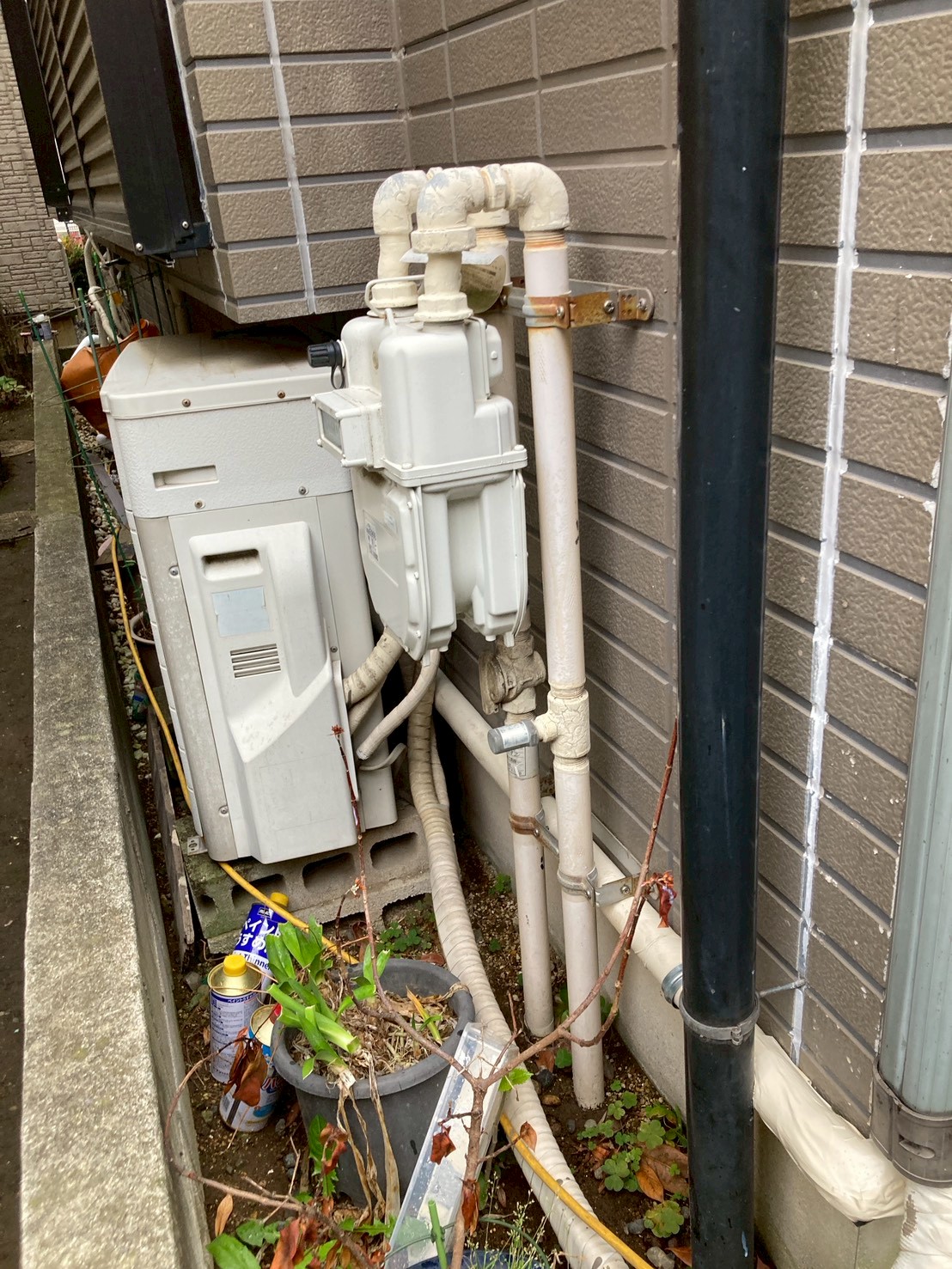 建物外壁の既存給湯・給水設備。配管の継手部分に錆と劣化が確認された