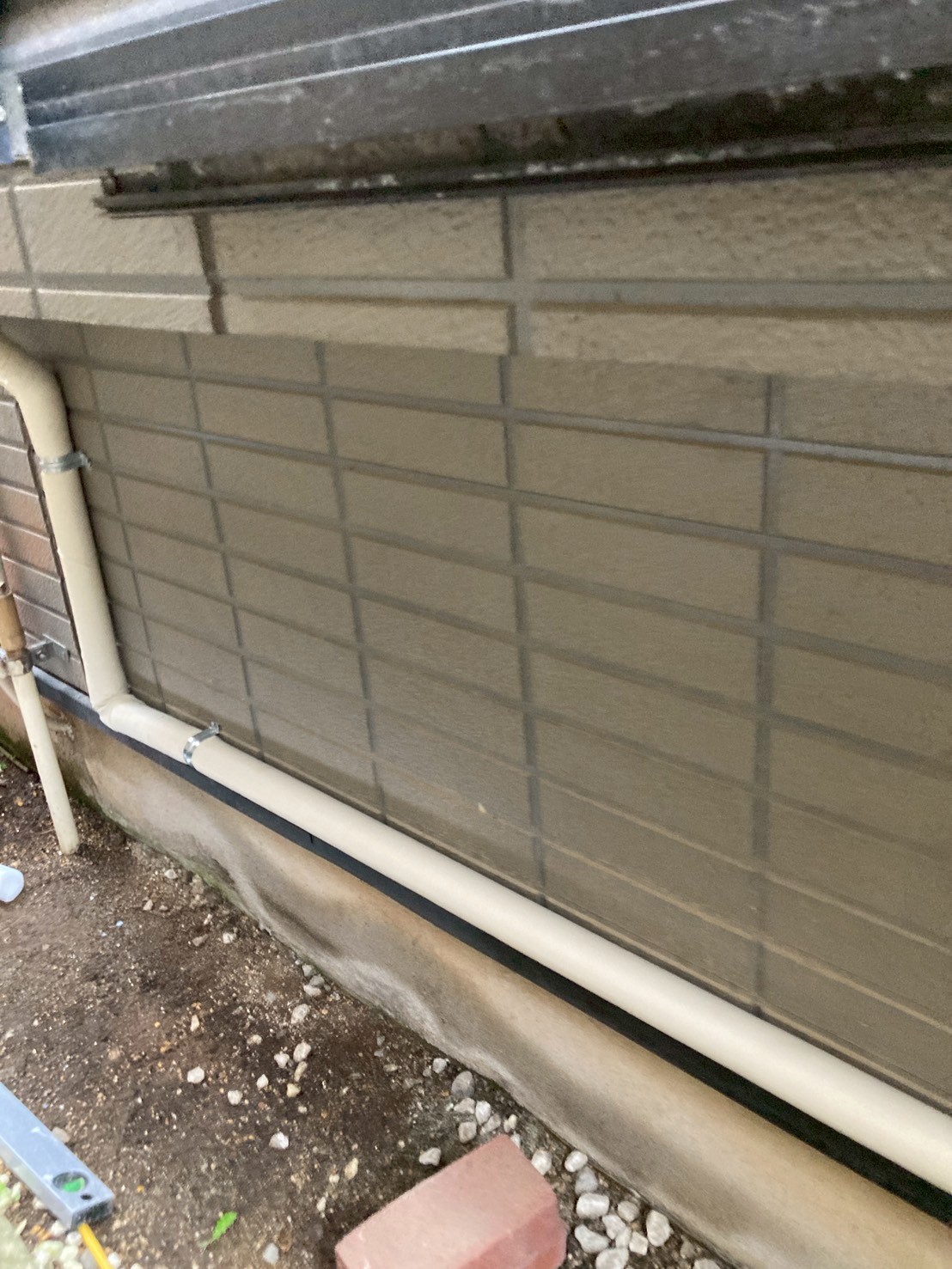 外壁基礎部分に新規保温付き配管を敷設している様子