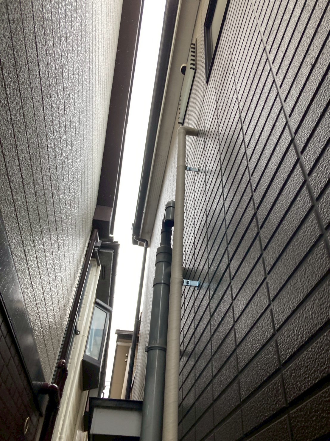 建物上部まで延伸された新規給水配管を下から見上げた様子