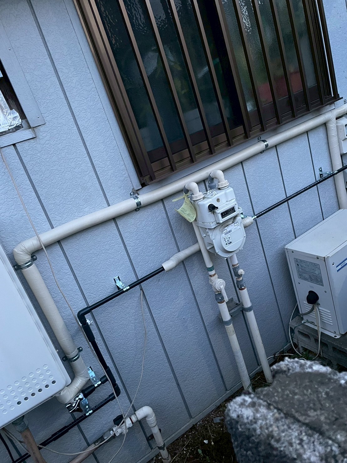 給湯器まわりの外壁配管。ガスメーターへの接続・給水管・給湯管が整然と整理されている