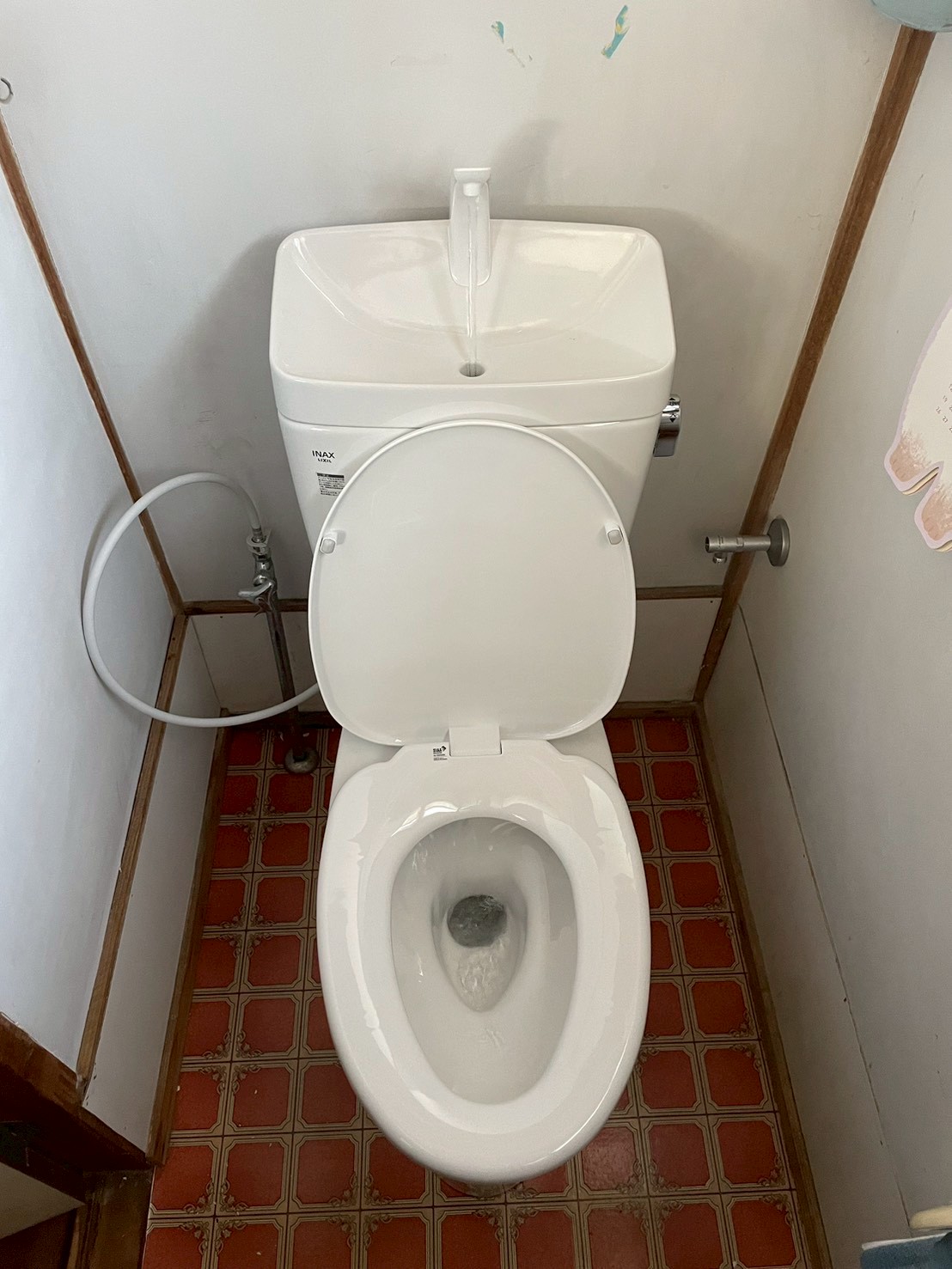 新品INAX製便器（タンク付き）の設置完了。ウォシュレット用フレキ管も接続済み