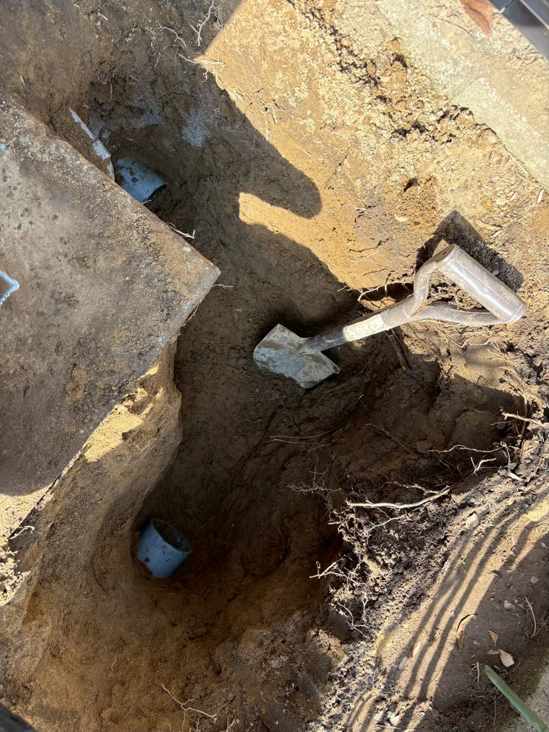 さらに深く掘削して排水桝の側壁と地中に埋設された配管の接続部が露出した状態