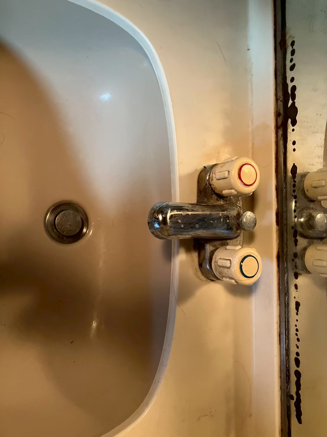 作業前の洗面台。2ハンドル混合水栓に錆・スケール汚れが著しく、水漏れが発生している状態