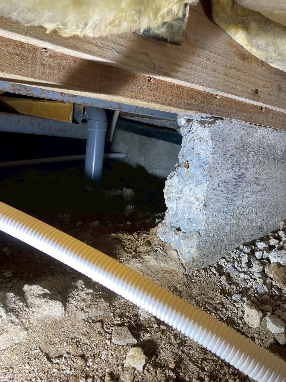 床下内部の様子。グラスウール断熱材の間に新規コルゲート管が通されている