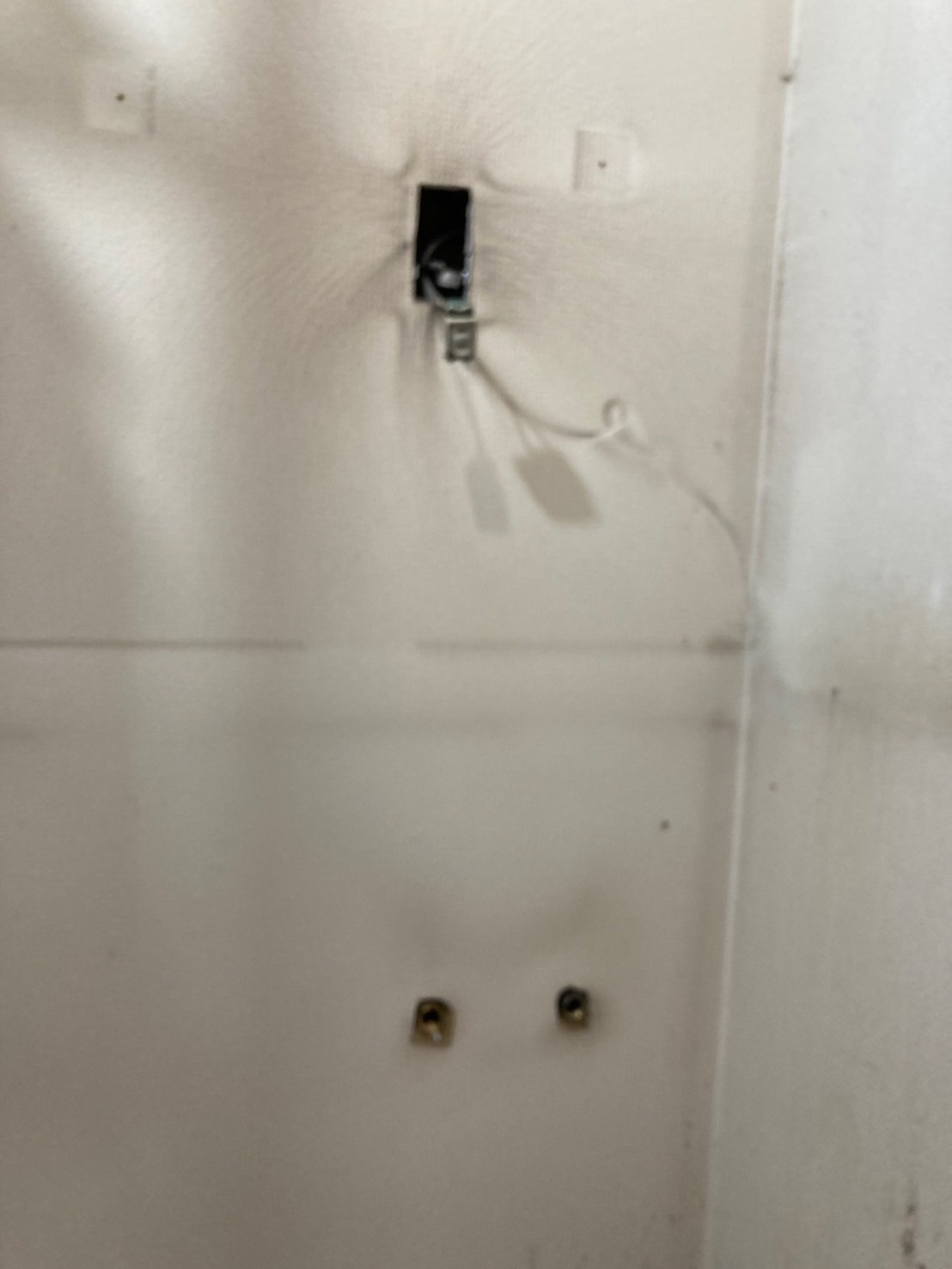 洗濯機置き場壁面への新規配管貫通部。給水・給湯の2口を確保