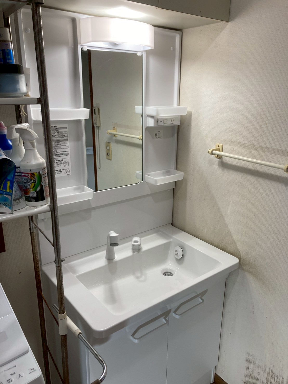 交換後の洗面所全体。清潔感ある白い新品TOTOの洗面化粧台・三面鏡・照明が設置されている