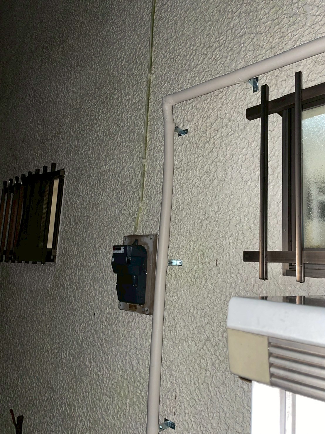 外壁2階付近で配管がL字に曲がり室内方向へ引き込まれている状態