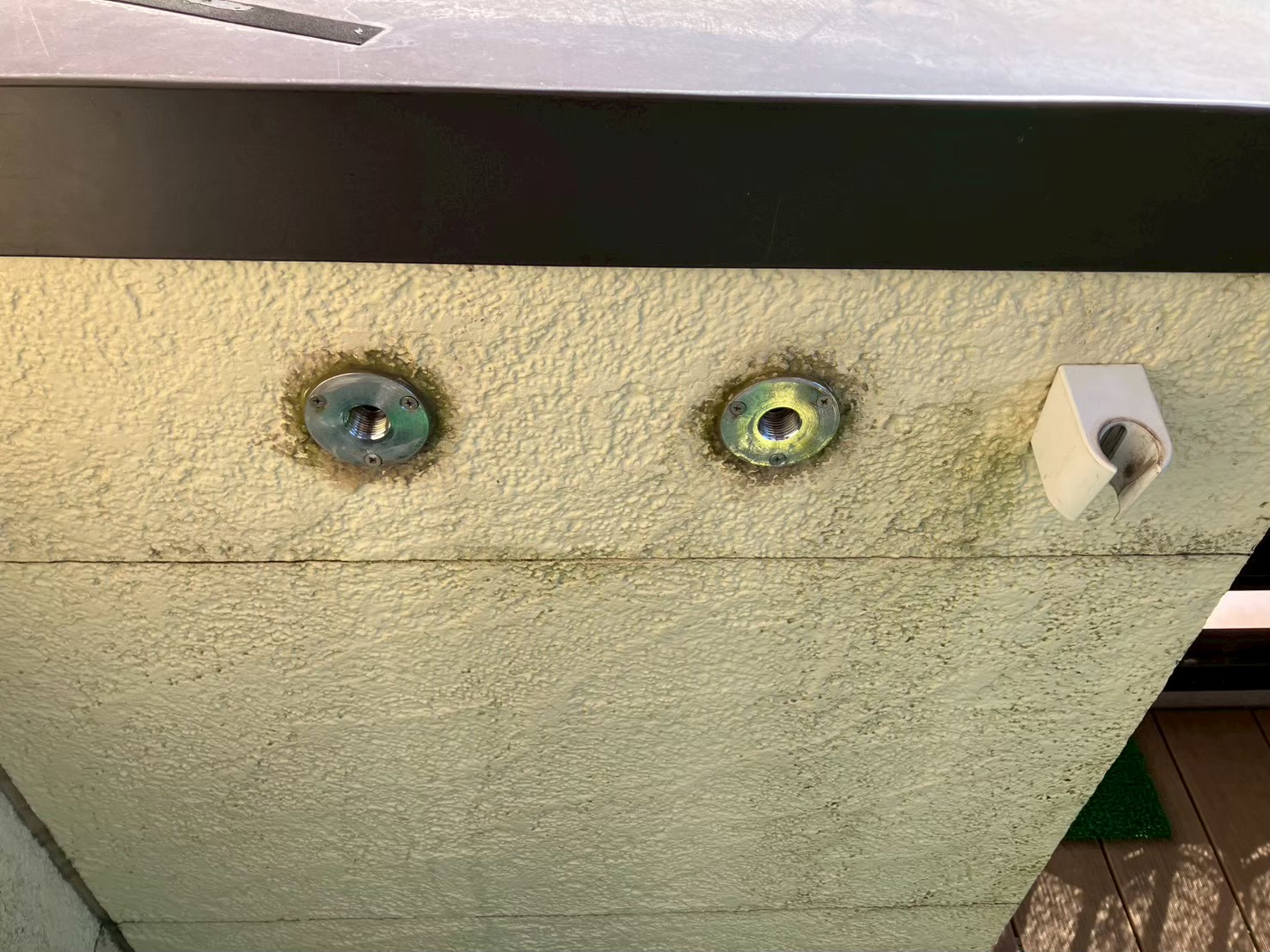 水栓本体撤去後の壁面。給湯口・給水口のウォールソケットが2箇所露出している