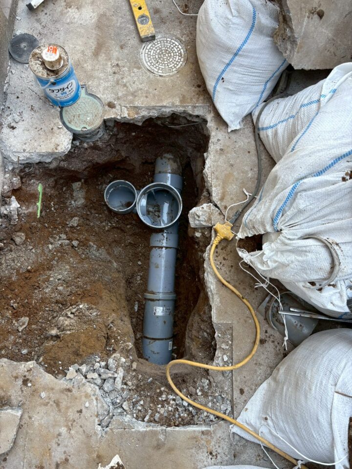 掘削部に新しい塩ビ管と継手を設置中