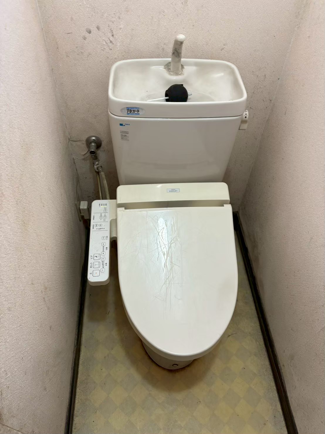 施工前のトイレ全体。INAX製旧型タンク付きトイレ。タンク蓋が外れた状態でフロートバルブが露出している