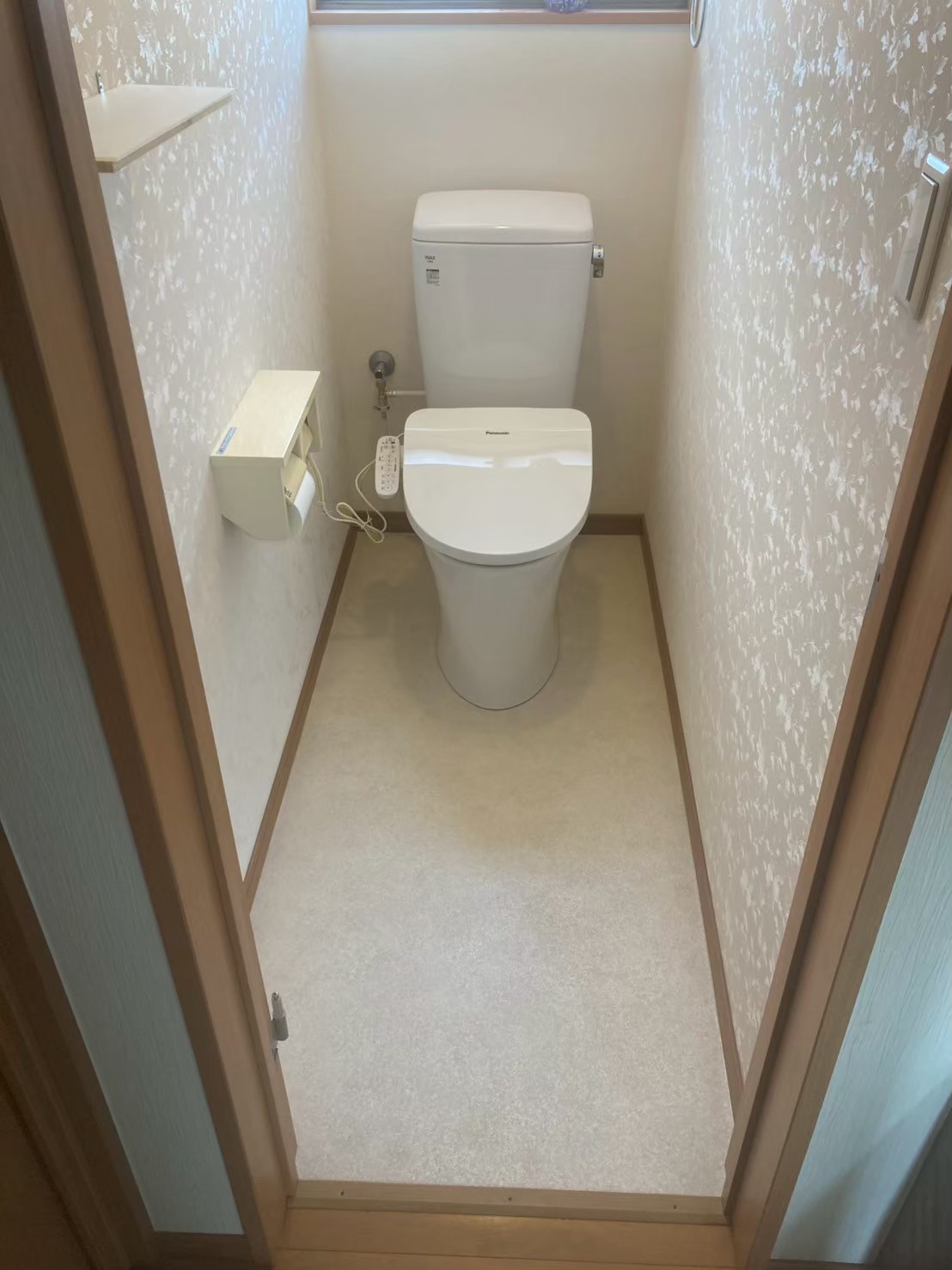 施工完了後の1Fトイレ全体。Panasonic製ウォシュレット一体型トイレが設置され、新しいクッションフロアと合わせて清潔感のある空間に生まれ変わった