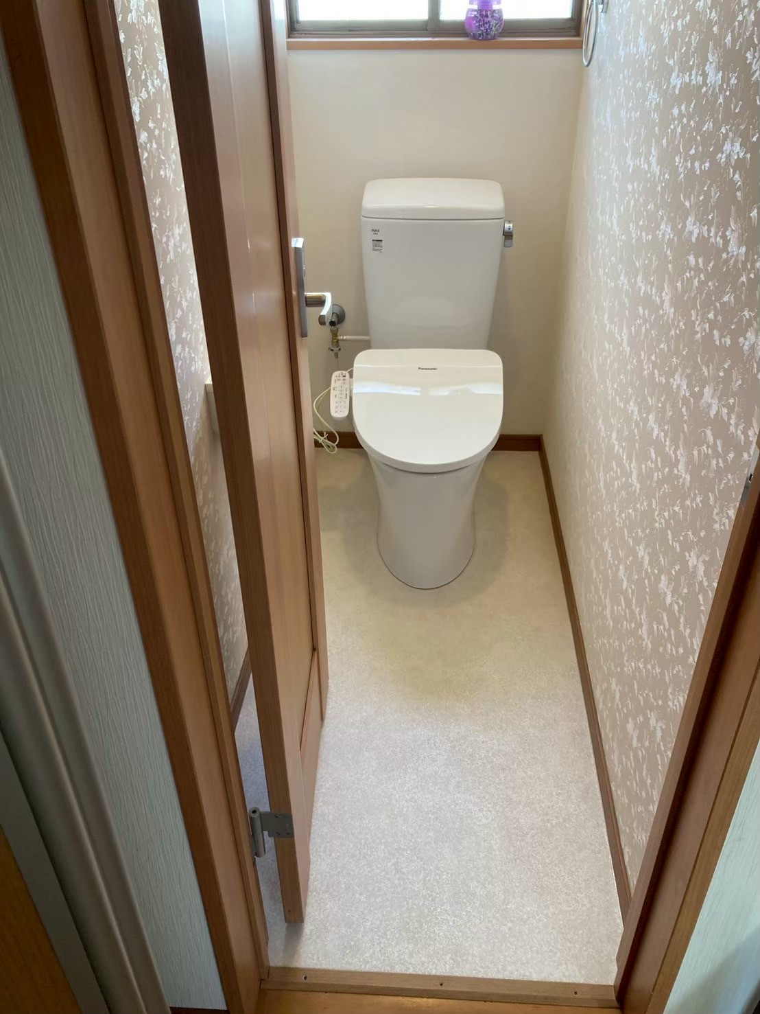 施工完了後のトイレ全体の最終確認写真。Panasonic製ウォシュレット一体型トイレ・新クッションフロアが施工され、清潔感のあるトイレ空間に仕上がっている