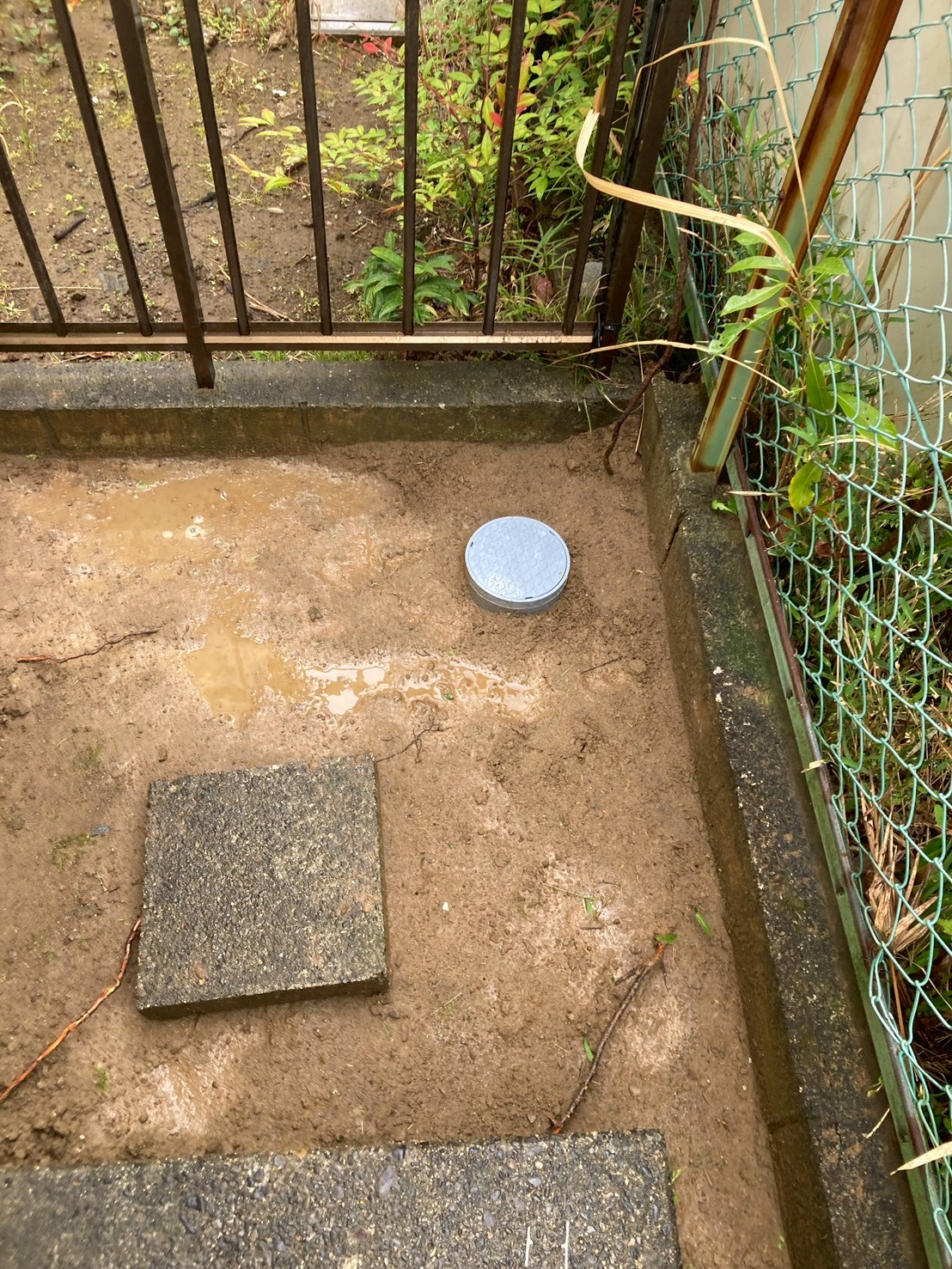 施工完了後の門扉付近。新設した樹脂製会所枡の蓋が地面に設置されている