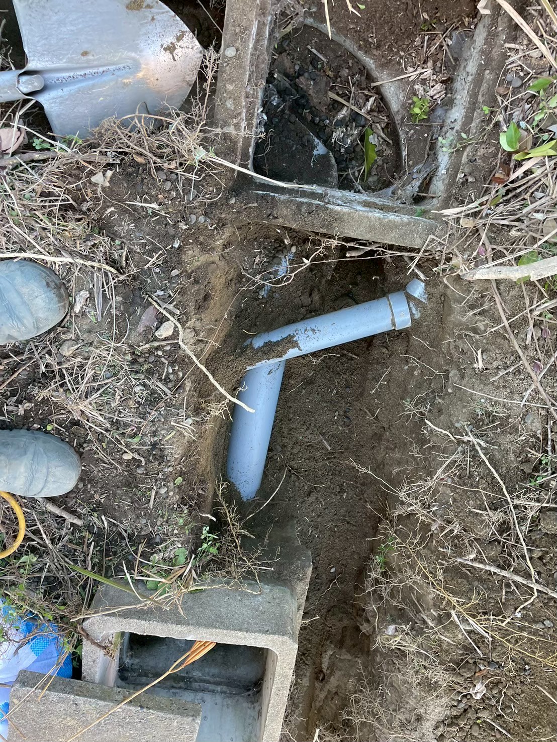 掘り起こした既存排水桝の内部。汚泥が堆積し管路がほぼ閉塞している状態。老朽化した排水管がトイレ詰まりの原因となっていた