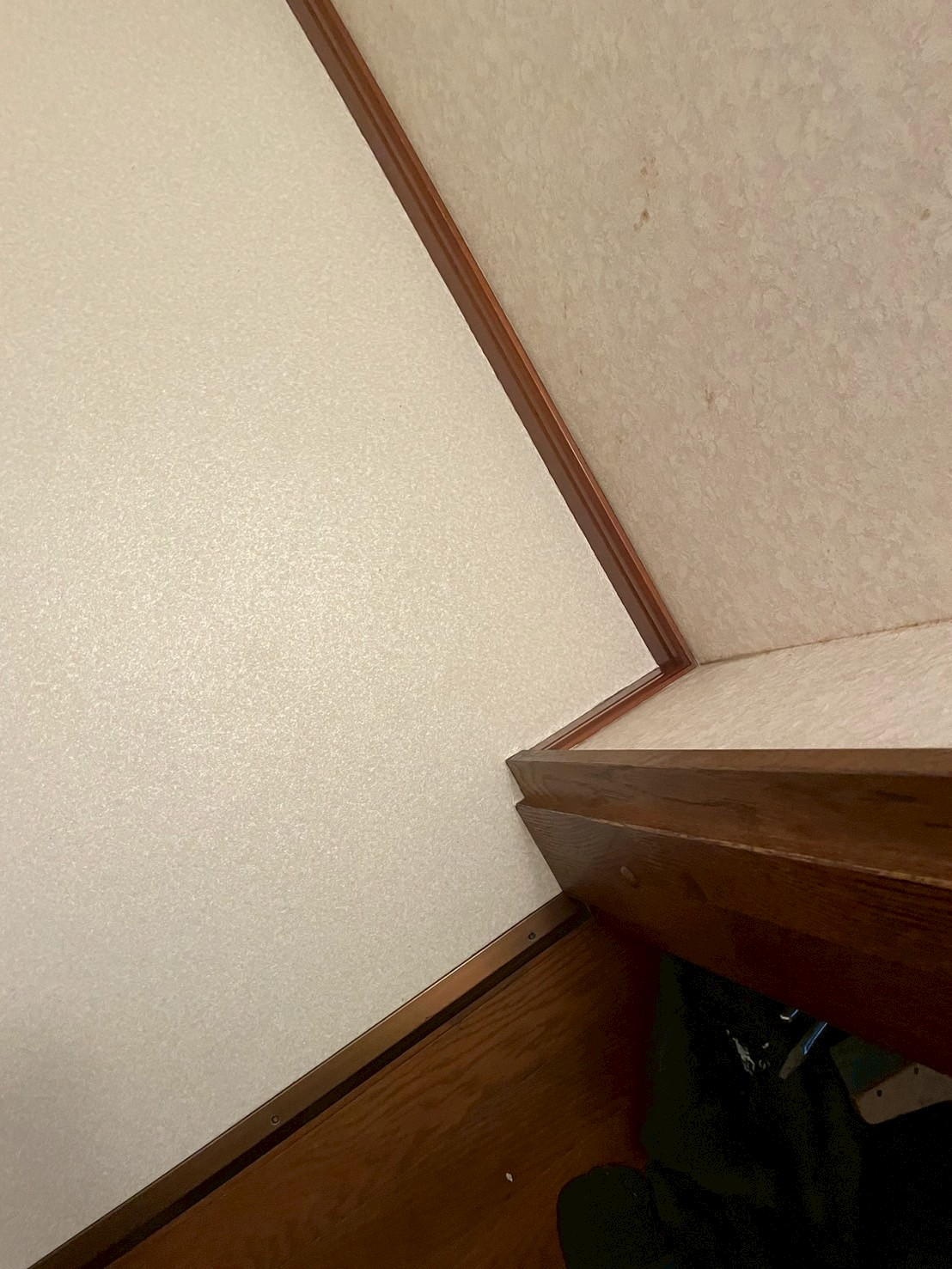 トイレ室入口の角部分。新しいクッションフロアと廊下フローリングの境界がきれいな見切り材で仕上げられている