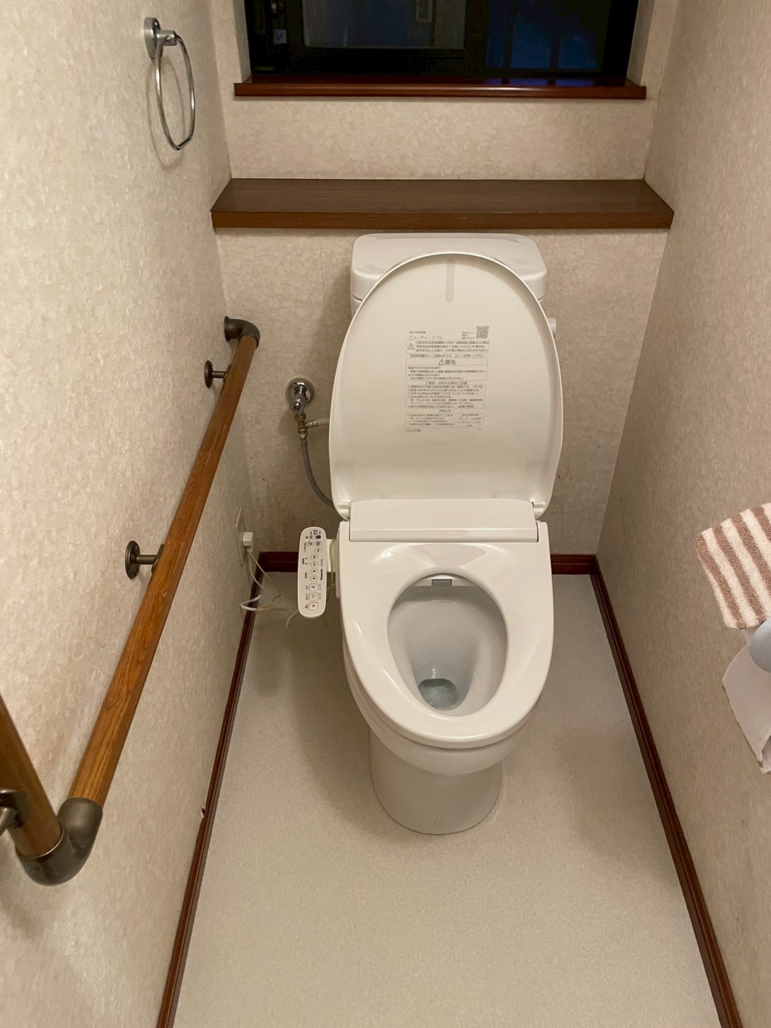 施工完了後の1Fトイレ全体。TOTO製ウォシュレット一体型トイレが設置され、新しい白系クッションフロアと合わせて清潔感のある空間に生まれ変わった