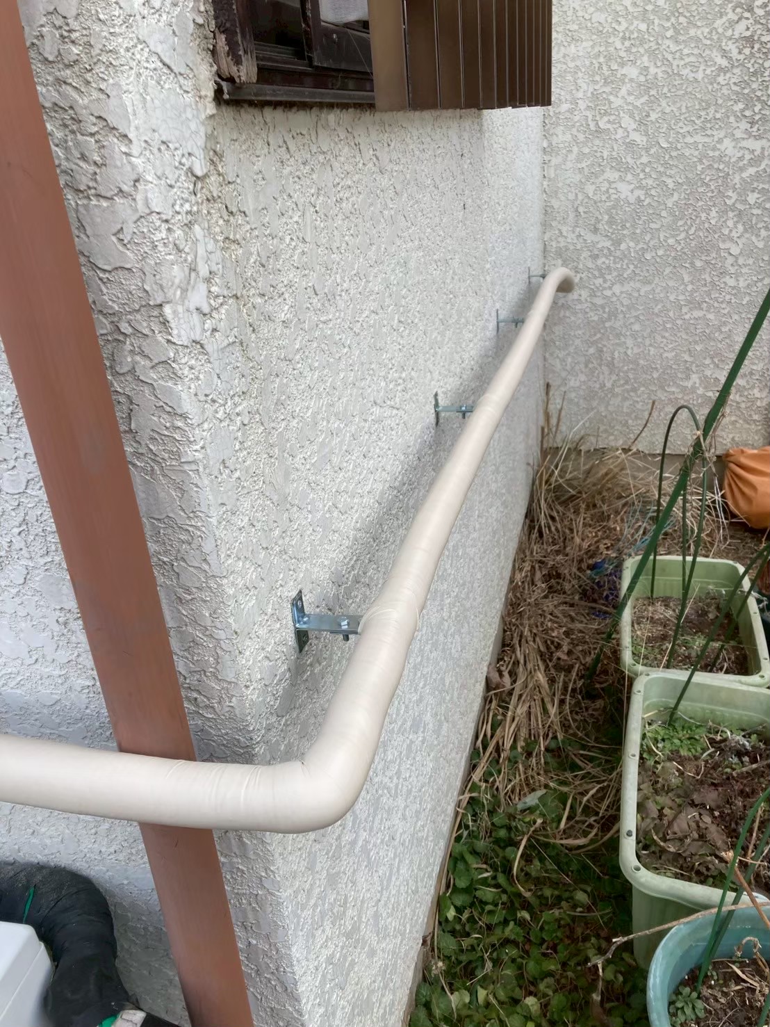 外壁沿いに保温材で被覆された給水管が整然と固定された完成状態