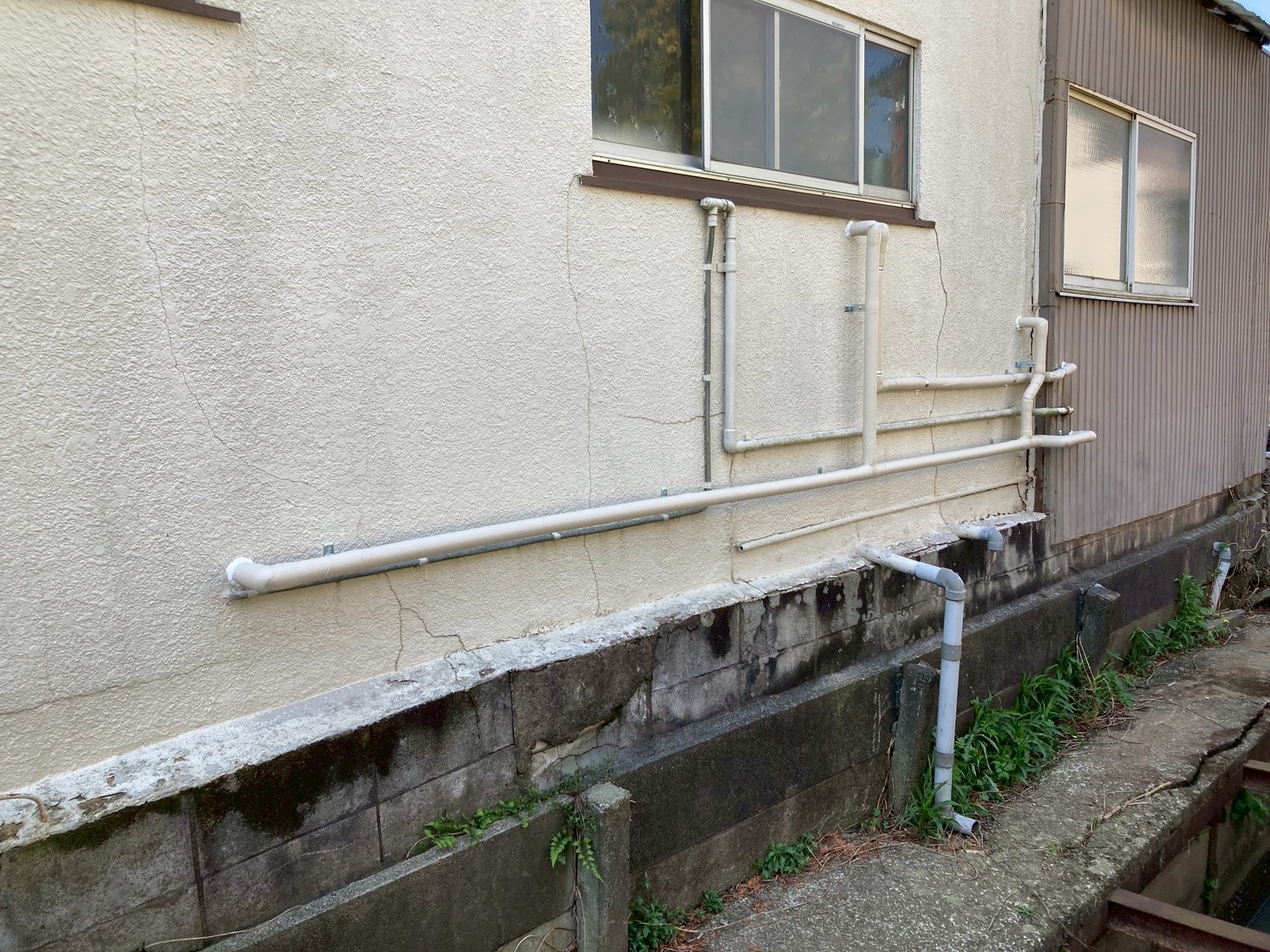 施工完了後の建物外壁。新しい給水・給湯管が外壁に沿って整然と固定されている