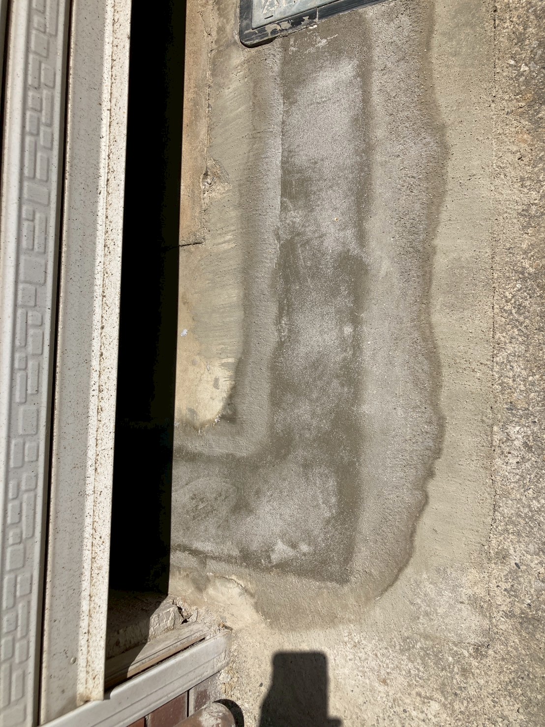 ガレージのコンクリート床面に広範囲の水漏れ痕跡が確認できる施工前の状態